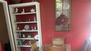 A dining area with a table and chairs, a bookshelf with decorative items, and a framed picture on the wall. - Pet friendly Spacious townhome, quiet neighborhood with pool, 1/2 mile to beach (St. Simons Island)