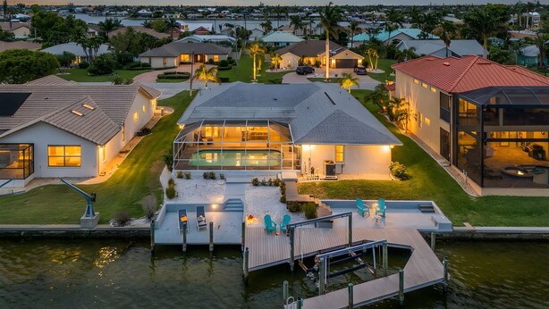 A waterfront property with a dock, swimming pool, and multiple houses.