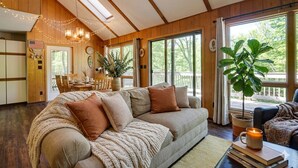 Ein gemütliches Wohnzimmer mit einer großen Couch, einem Essbereich und Blick ins Freie.