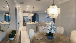 A modern kitchen with a central island, white cabinetry, and a stainless steel refrigerator. - Fabulous 3-bedroom house with private pool and endless amenities in Estero (Estero)