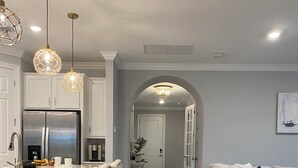 A modern kitchen with a central island, pendant lights, and a built-in refrigerator. - Fabulous 3-bedroom house with private pool and endless amenities in Estero (Estero)
