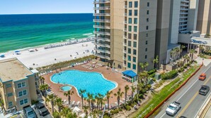 A hotel with a pool, beach access, and a view of the ocean.