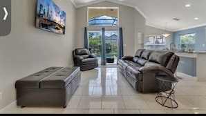 A modern living room with a large sectional sofa, a coffee table, and a painting on the wall.