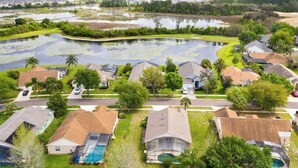 A residential area with houses, a swimming pool, and a large body of water.