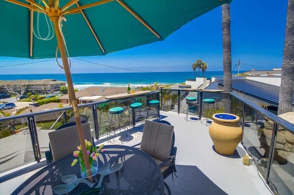 A balcony with outdoor seating, a large vase, and a view of the ocean. - The Jetson House - 2 BD duplex top unit ocean view (San Diego)