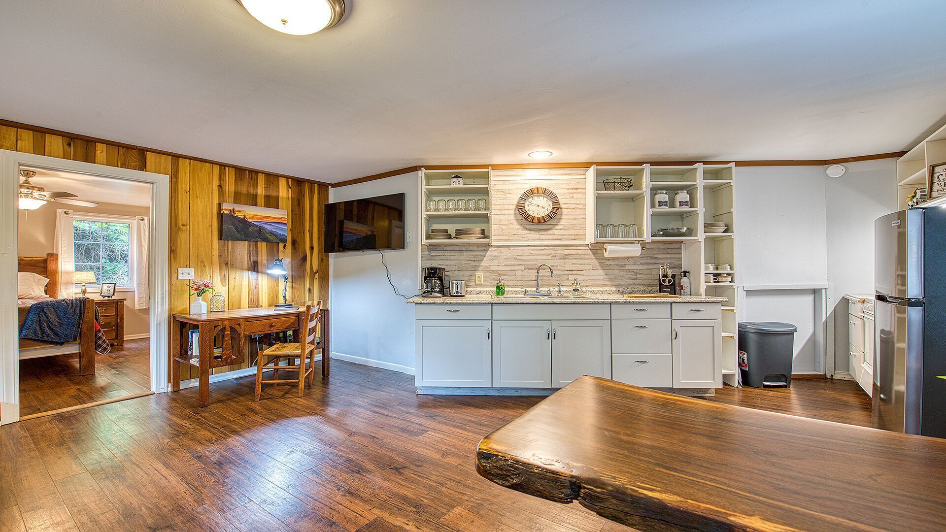 Una cucina moderna con mobili in legno, forno integrato e zona pranzo con tavolo e sedie in legno.