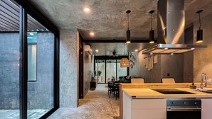 A modern kitchen with a large island, stainless steel appliances, and pendant lighting.