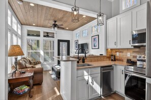 A modern kitchen with white cabinetry, a wooden ceiling, and a built-in oven. - Upscale Tiny Home Near Wineries Pet Friendly (Blairsville)