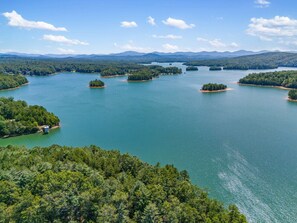 A large body of water surrounded by dense forest and distant mountains. - Pet Friendly Tiny Home Retreat Near Blue Ridge (Blairsville)