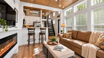 Un interior moderno con chimenea, un sofá, una mesa de centro y una zona de cocina.