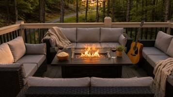 Una terraza con un brasero, asientos y una guitarra.