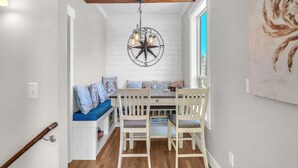 A dining area with a wooden bench, a table, and chairs. - Sand Seeker in Olivia Beach (Lincoln City)