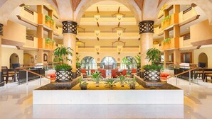 A spacious lobby with multiple floors, large columns, and potted plants. - Enjoy your Thanksgiving in the Sun and on the Beach Los Cabos (Cabo San Lucas)