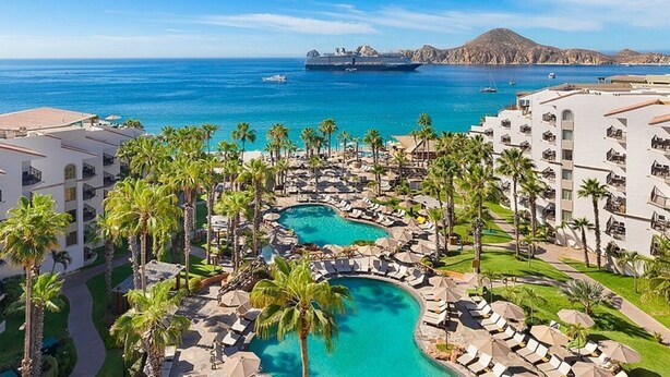 A resort with multiple swimming pools, palm trees, and a view of the ocean. - Enjoy your Thanksgiving in the Sun and on the Beach Los Cabos (Cabo San Lucas)