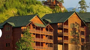 A log cabin-style hotel with multiple balconies and a stone foundation.
