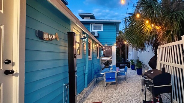A blue building with a sign reading "BEACH" and outdoor seating with a grill. - Charming 2-bedroom house with WiFi, AC in beautiful Treasure Island (Treasure Island)