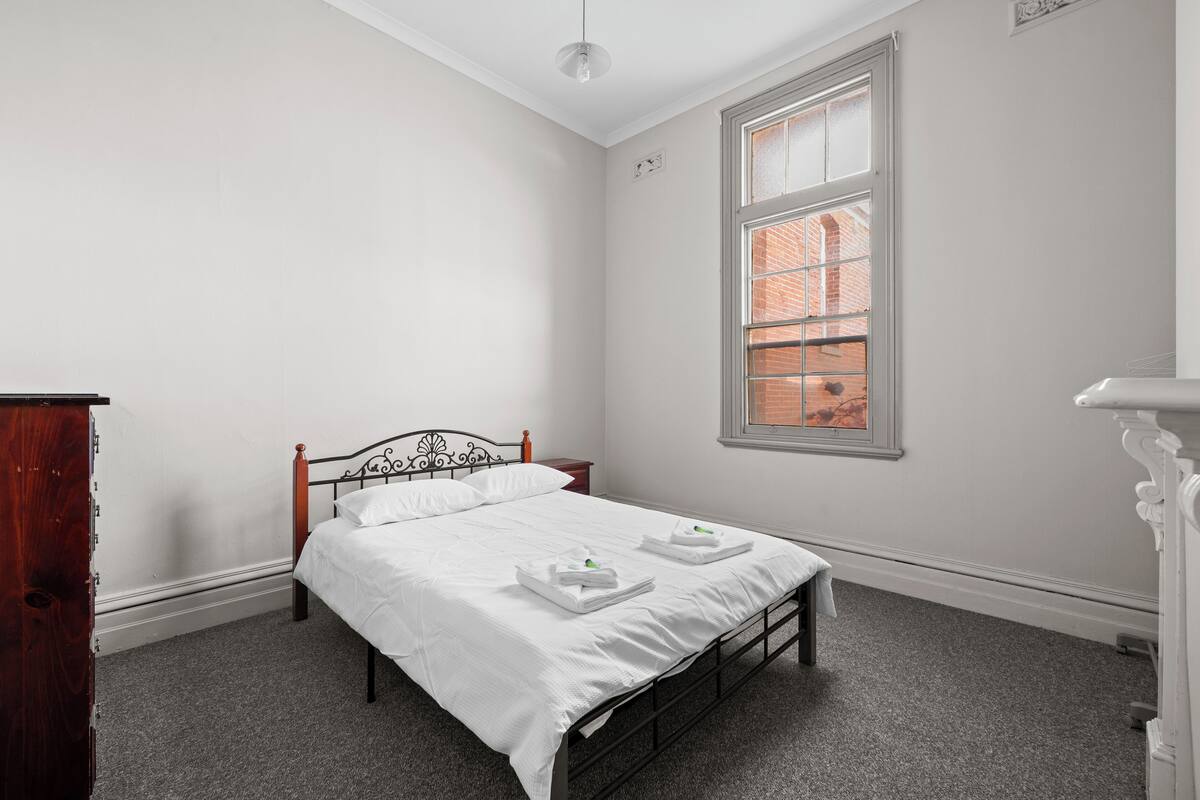 Un dormitorio con cama, ventana y cómoda.