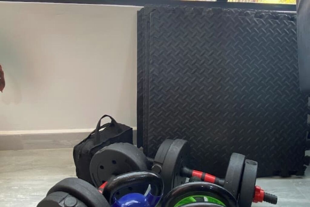 Une paire d’haltères et un banc de musculation dans une salle de sport.