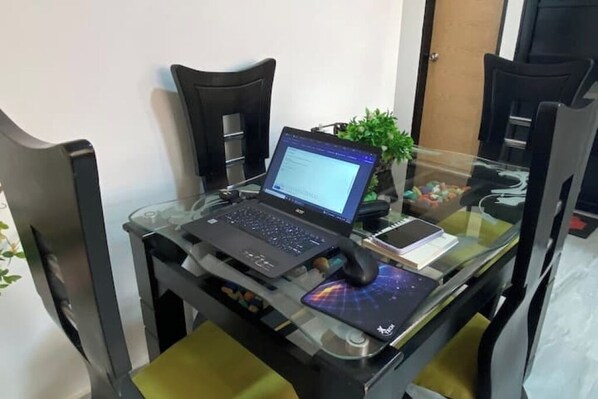 A laptop on a glass table with a mouse, a notebook, and a potted plant. - Apartment in downtown Marinilla (Marinilla)