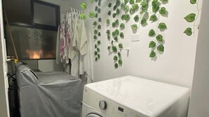 A laundry area with a washing machine and a drying rack.