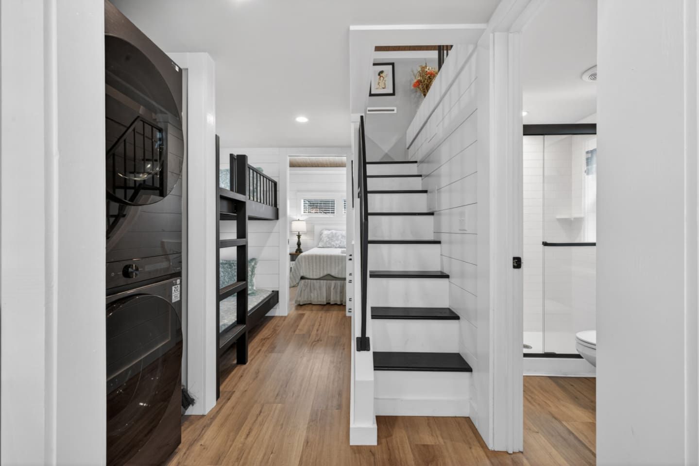 Ein modernes Interieur mit einer Treppe zu einem Schlafzimmer, einer Küchenzeile mit Herd und einem Badezimmer mit Toilette.