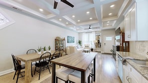 A spacious kitchen with a wooden dining table, chairs, and a built-in oven. - Charming 3-bedroom house in delightful Louisville with beautiful flower garden (Louisville)