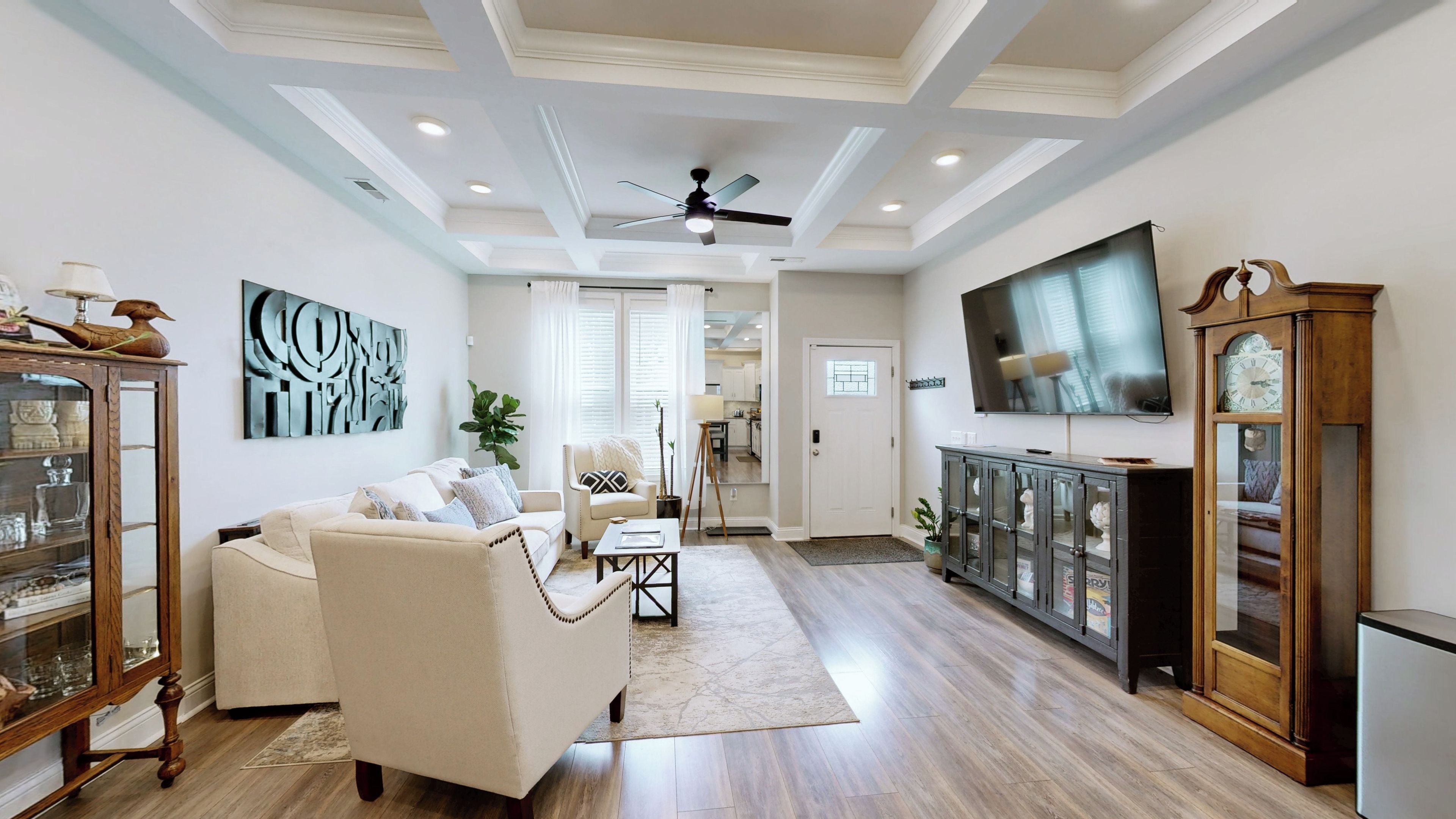 A spacious living room with a sofa, coffee table, and a television.