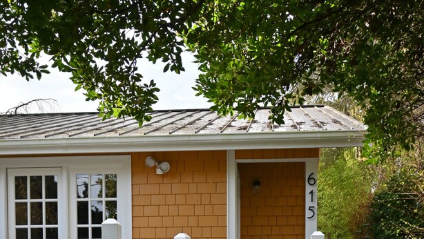 A house with a brick exterior, white front door, and a small porch with a white railing. - Charming 2-bedroom house in downtown Langley. (Langley)