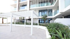 Un edificio moderno con un espacio exterior cubierto, varios pisos y un balcón.