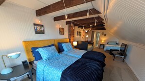 A bedroom with a large bed, bedside tables, a desk, and a chair. - Hershey Music Box 2 - Duplex near HersheyPark, Giant Center, Hershey, Palmyra (Hummelstown)