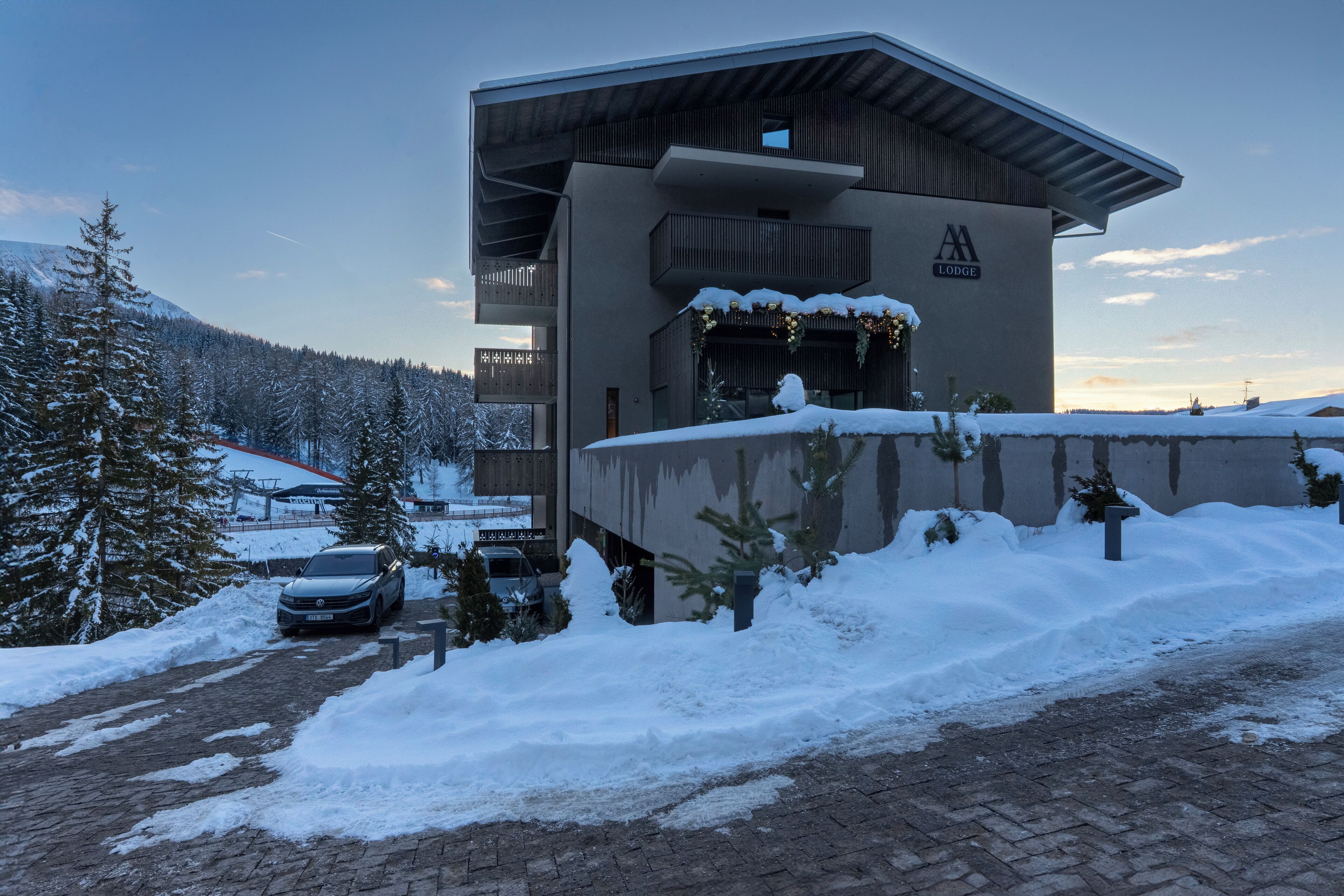Eine moderne Lodge mit schneebedecktem Dach und einem Schild mit der Aufschrift 'Lodge'.
