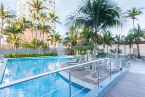 Ein Swimmingpool mit Liegestühlen und Palmen.