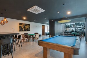 A pool table in a modern indoor setting with a bar area and seating. - Hermosa Vista En Piso 23 En Camino Al Mar (Mazatlan)