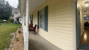 A house with a covered porch, a visible door, and a small garden area. - The Good Life Place in Smyrna (Smyrna)