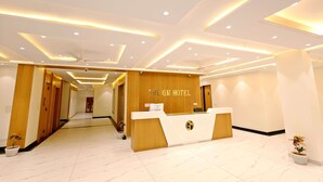 Ein Hotel-Empfangsbereich mit modernem Design, der einen Empfangstresen, Holzakzente und einen sauberen, gefliesten Boden zeigt.