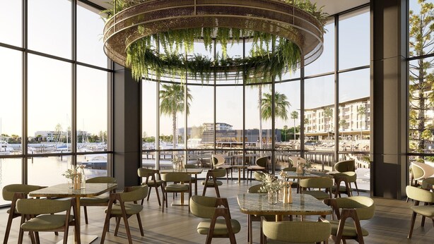 A spacious indoor dining area with large windows, modern furniture, and a hanging plant chandelier.