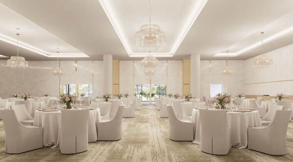 A spacious banquet hall with round tables and white chairs, large chandeliers, and a view of greenery outside. - Crowne Plaza Shell Cove Marina (Wollongong)