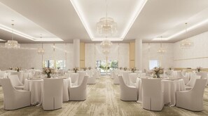 A spacious banquet hall with round tables and white chairs, large chandeliers, and a view of greenery outside. - Crowne Plaza Shell Cove Marina (Wollongong)