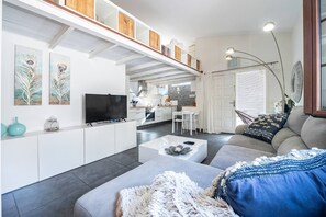 Uma sala de estar moderna com sofá, mesa de centro e obras de arte na parede.