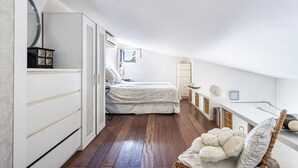 Un dormitorio con cama, cómoda, espejo, ventana y zona de escritorio.