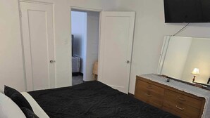 A bedroom with a bed, a dresser, a ceiling fan, and a TV mounted on the wall. - "Breaking Bad !"  Neighborhood -3-bedroom house  Albuquerque with WiFi, AC (Albuquerque)