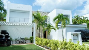 A modern two-story house with a garage, a covered patio, and a lawn.
