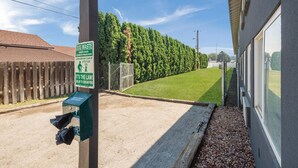 Una estación de recogida de desechos de perro con un cartel que indica una multa por incumplimiento.