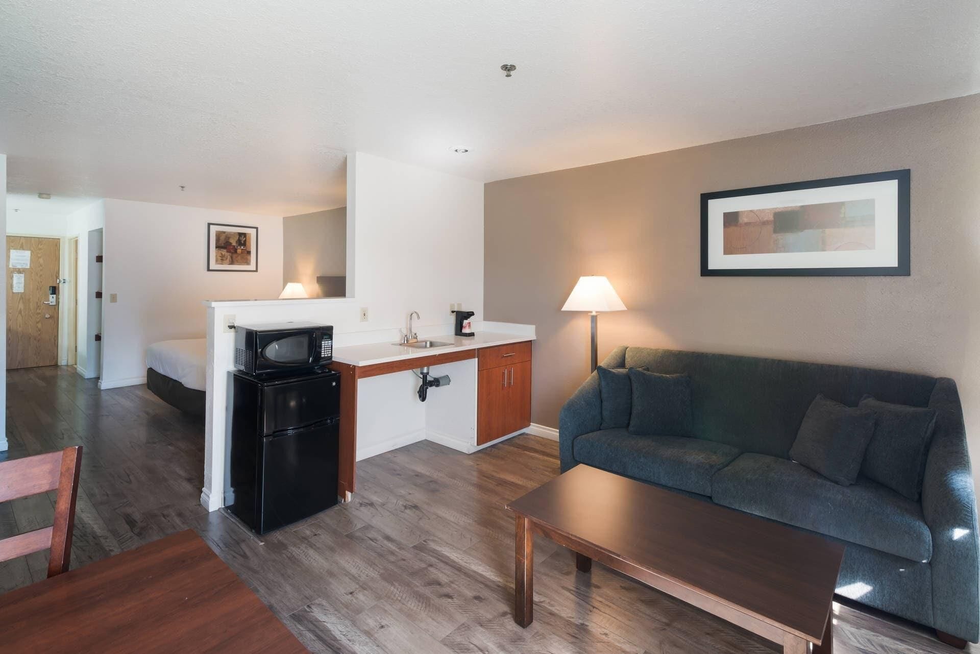 A compact living space with a kitchenette, a sofa, and a dining table.