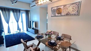 A modern dining area with a glass table, wooden chairs, and a hanging light fixture. - BAYSHORE RESIDENTIAL RESORT 2 PHASE 1 (Parañaque)
