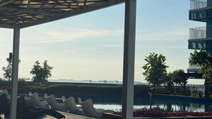 A pool area with lounge chairs and a covered seating area. - BAYSHORE RESIDENTIAL RESORT 2 PHASE 1 (Parañaque)