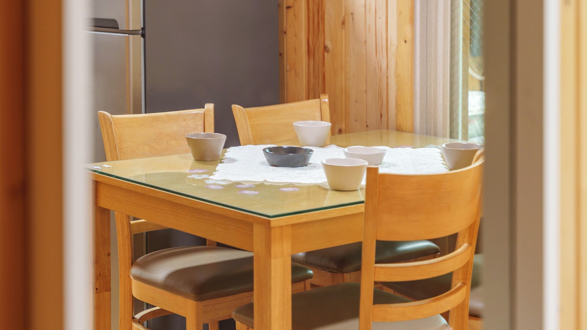 Een eettafel met zes stoelen, een placemat en diverse schalen.