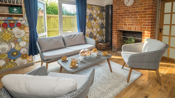 A cozy living room with a sofa, chairs, a coffee table, and a fireplace. - Sampford Hideaway Retreat (Little Sampford)