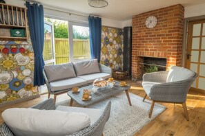A cozy living room with a sofa, chairs, a coffee table, and a fireplace. - Sampford Hideaway Retreat (Little Sampford)