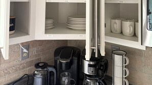 A kitchen with white cabinets, a coffee maker, and a kettle. - Charming 3 Bedroom 2.5 bathroom finished basement, Huge yard and Charcoal grill (Baraboo)